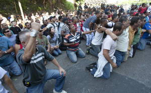 Bombeiros e familiares se ajoelham em frente ao local onde presos após invadirem o quartel central durante protesto por melhores salários Leia mais