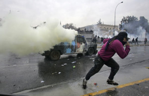 Manifestante foge da polícia durante protestos em Santiago, nesta quinta (Foto: Cristobal Saavedra/Reuters)