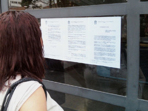 Mulher lê comunicado colado na porta de entrada da PUC-SP na manhã desta sexta-feira (16) explicando as razões do fechamento do campus Monte Alegre (Foto: Paulo Guilherme/G1)